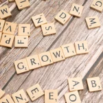 scrabbled letters spelling growth on a wooden surface